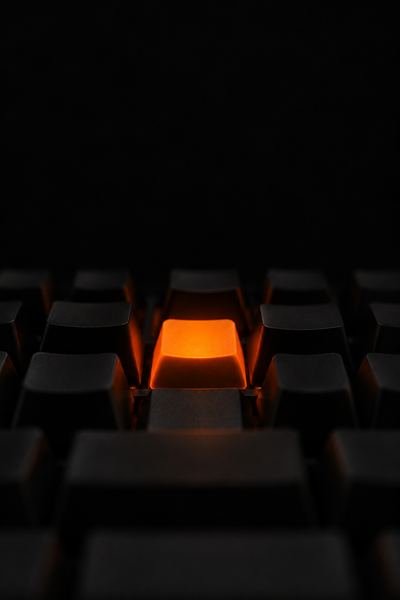 Teclado preto com uma tecla laranja acesa